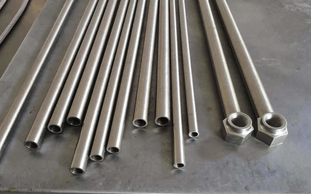 Tubos de acero inoxidable de diámetro pequeño (tubing de 6, 8 y 10 mm) sobre un banco de trabajo